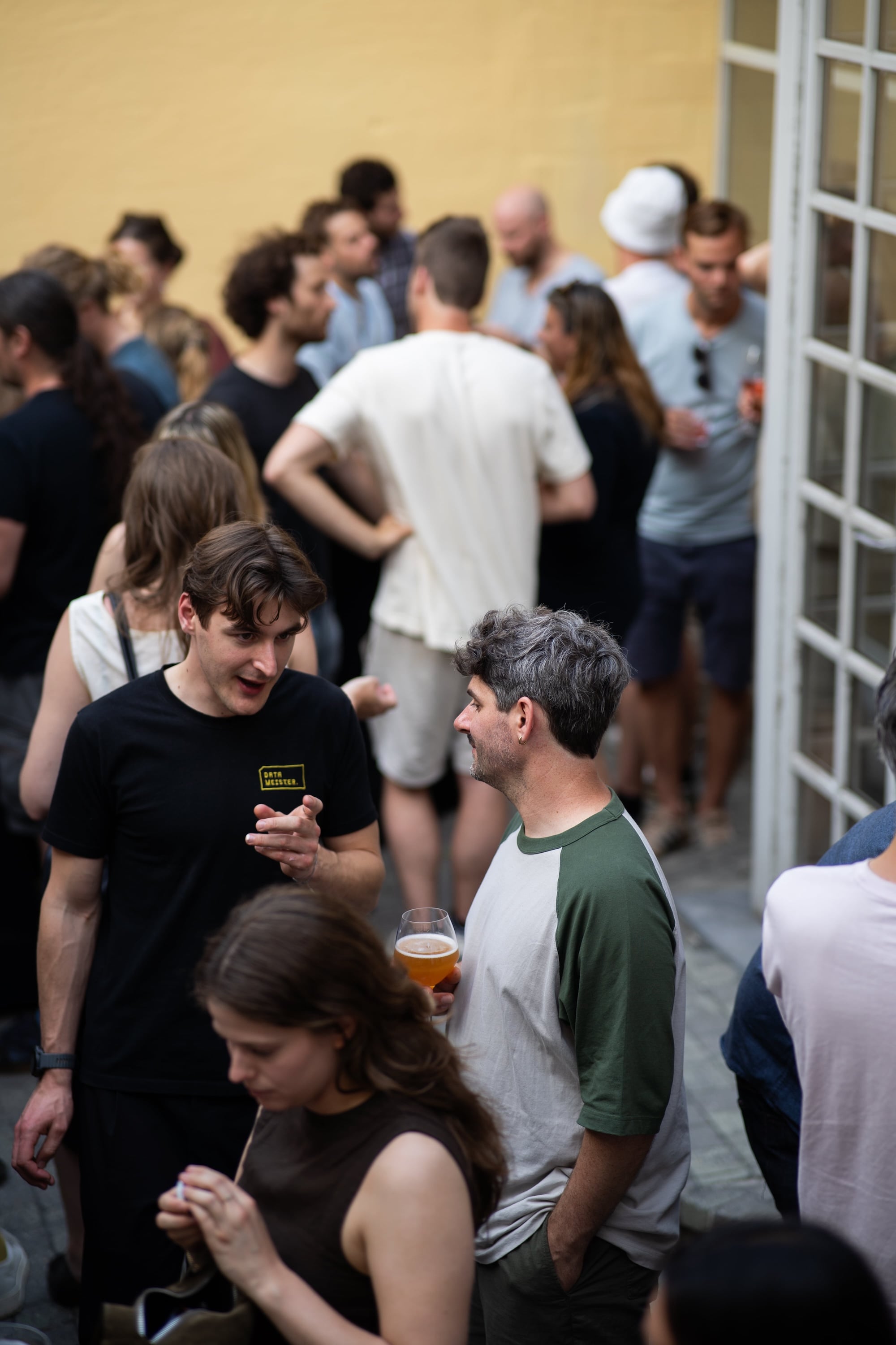 Datameister team and guests talking over drinks at an outdoor event